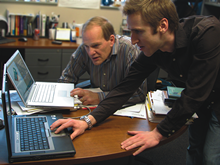 James Miller and David Wolfe working on laptops