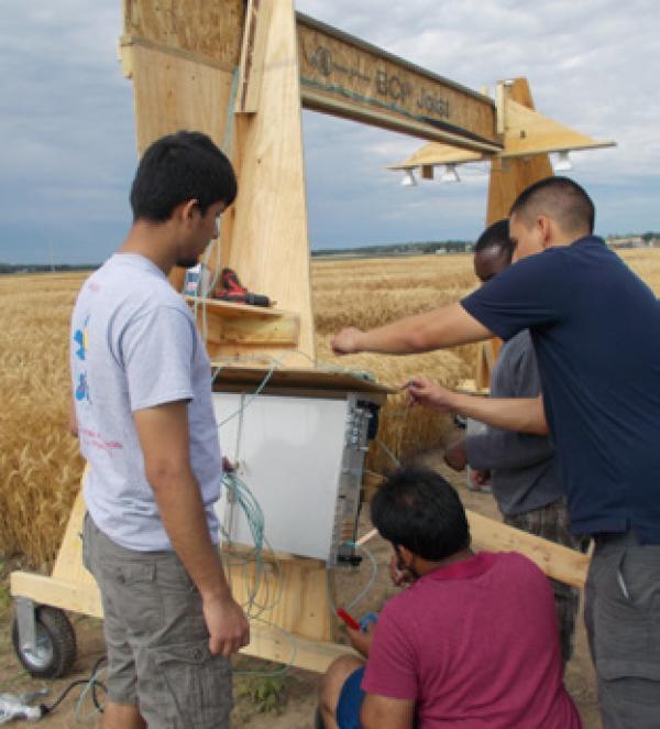 people working on a piece of equipment in a field