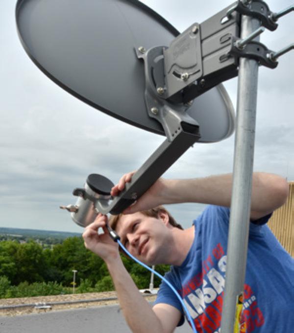 person working on a satellite dish